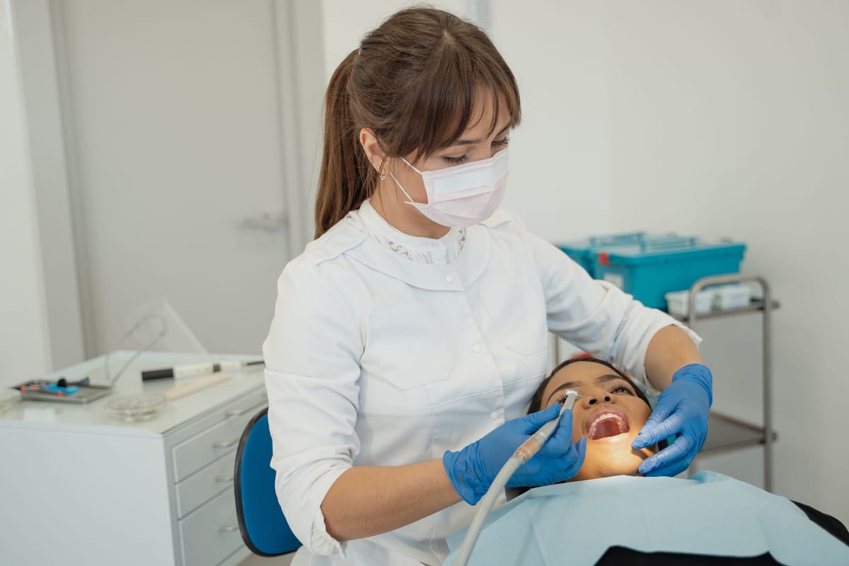 A dentist working chairside with a patient in a bright modern clinic