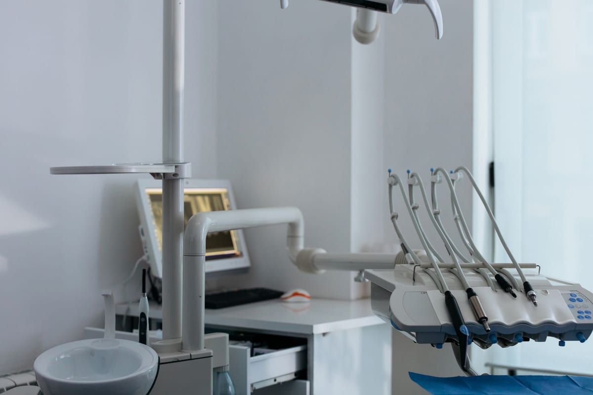 A treatment room with the planning screen and instrument arm ready beside the chair