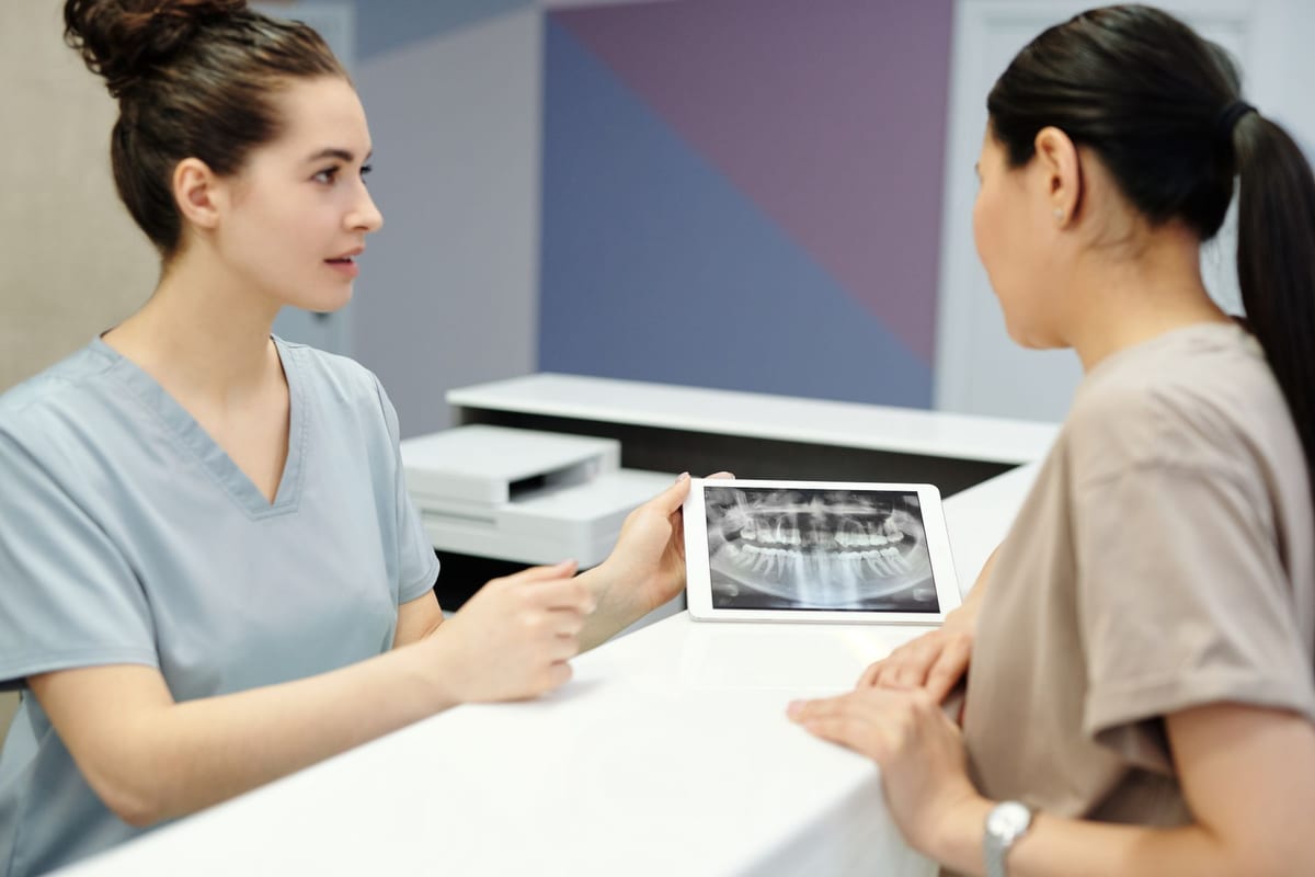 A dentist going through an x-ray with a patient at the chairside